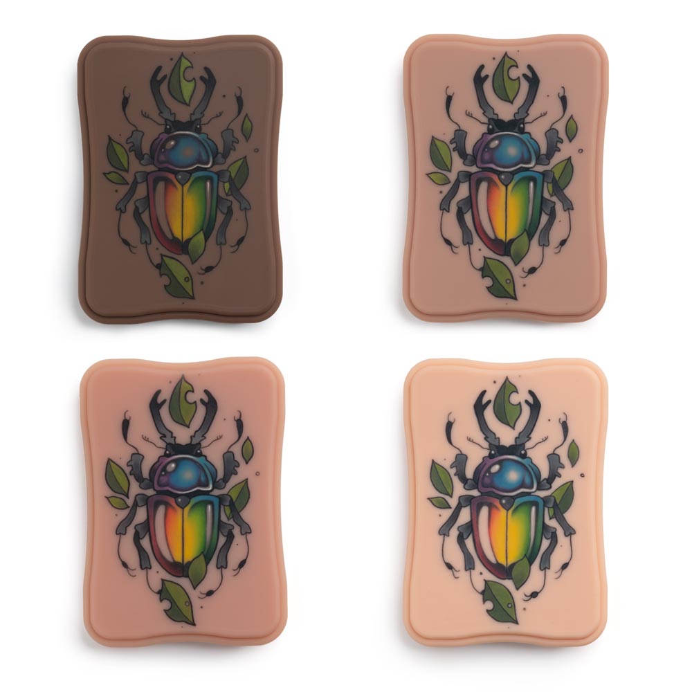 Example tattoo of rainbow beetle with leaves on four APOF Micro Plaques in Fitzpatrick tones 2, 3, 4, and 5